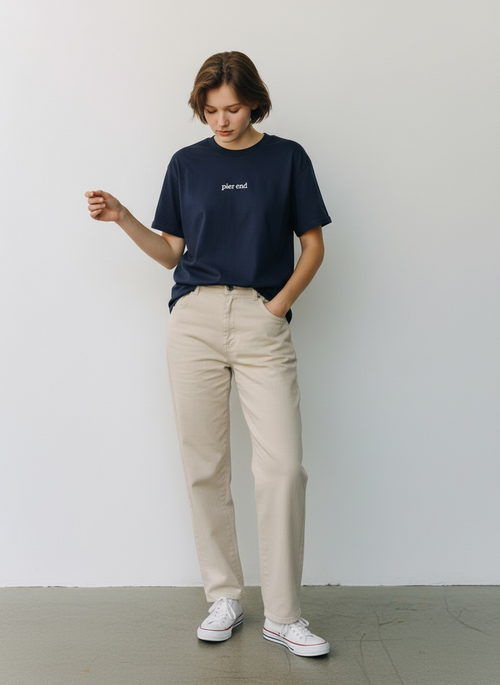 Female model wearing navy organic tshirt in a studio setting