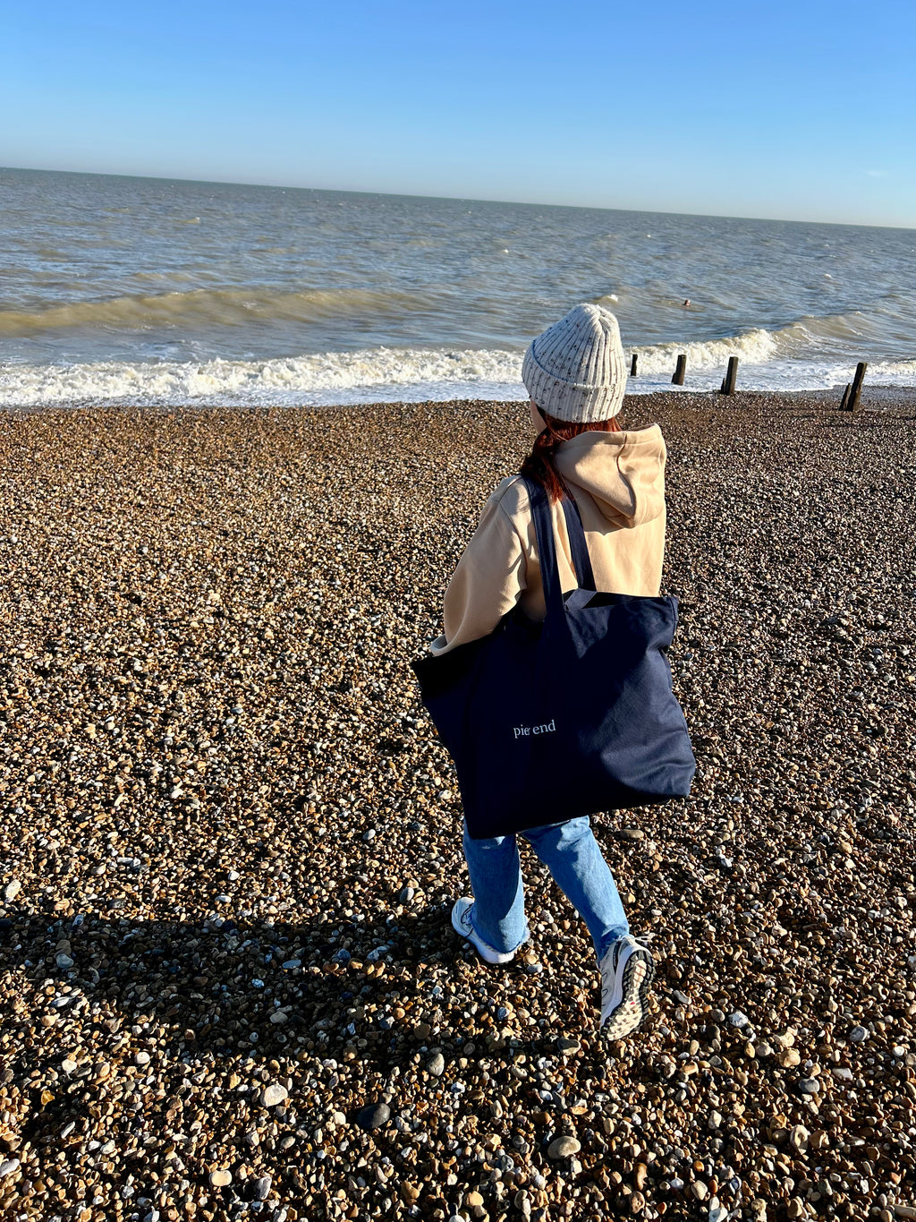 Navy canvas tote carried over the shoulder at the coast