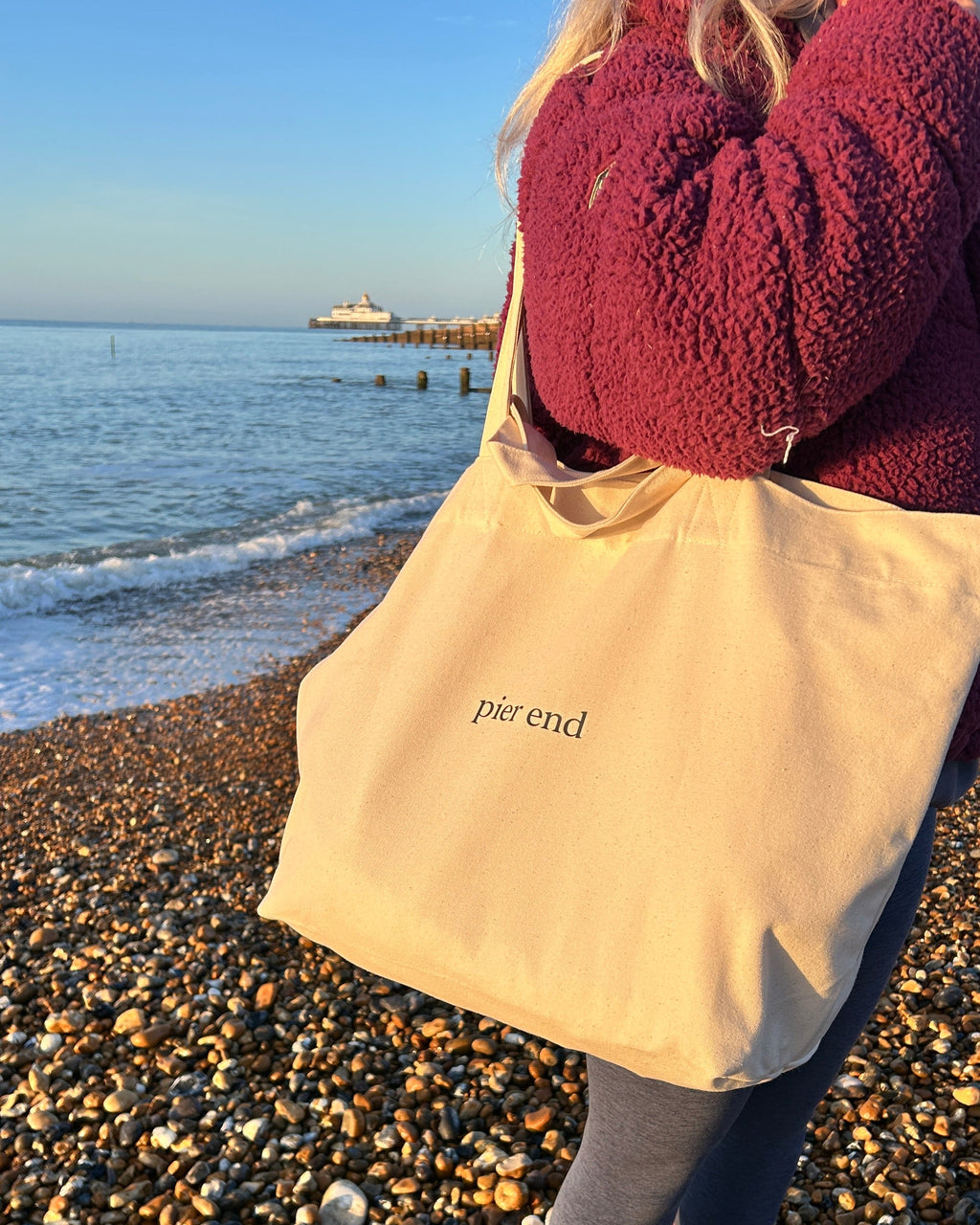 Natural canvas tote carried over the shoulder at the beach