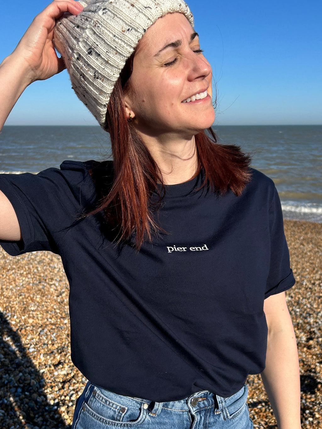 Female customer wearing the Navy crewneck tshirt on the beach