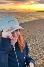 Oyster cap being worn on the beach at sunset